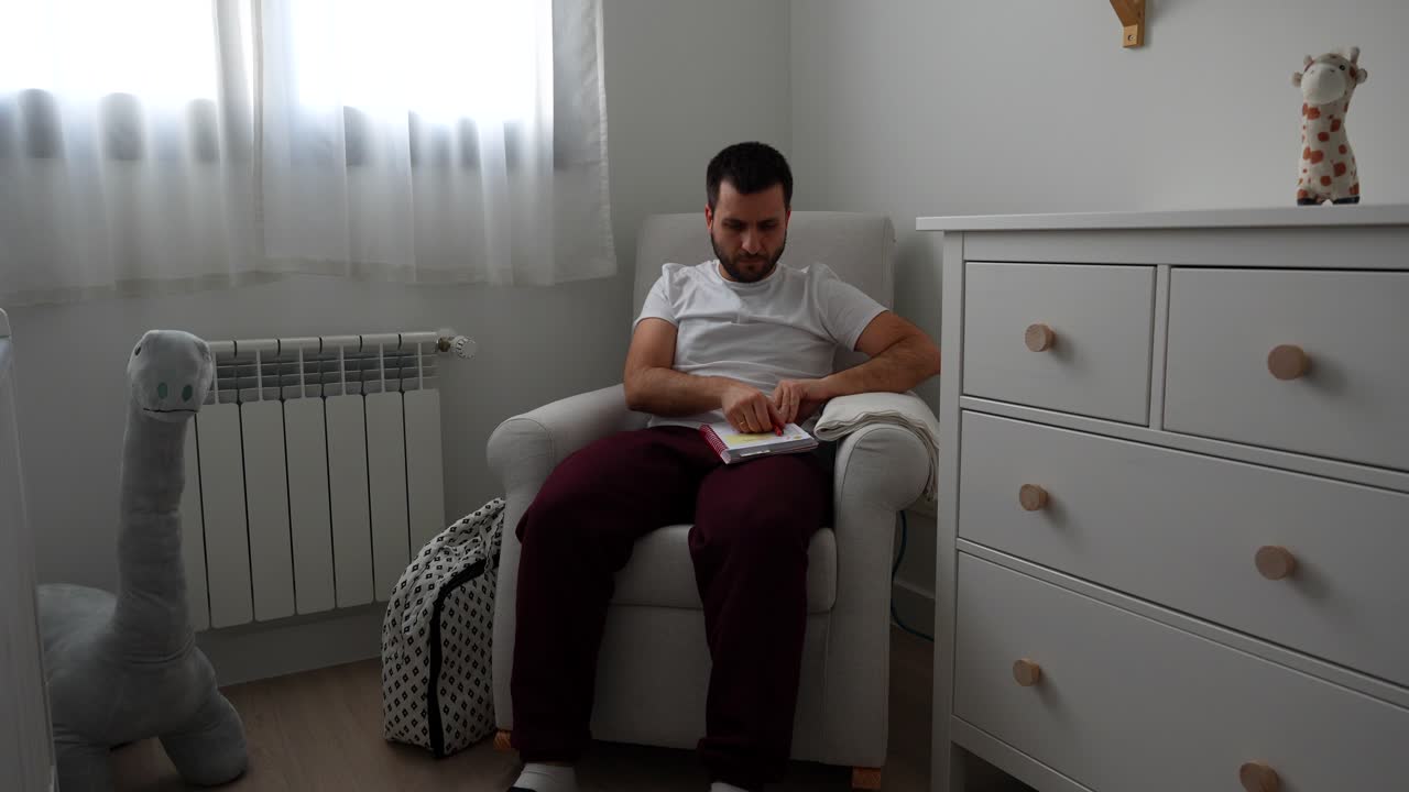 Man in baby room touches soft dinosaur toy and picks up notebook with hospital checklist