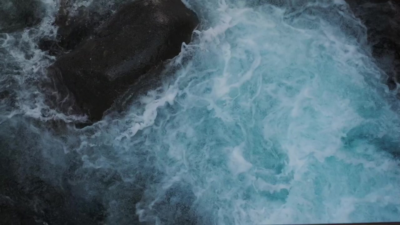 Ripresa al rallentatore dell'acqua del fiume che scorre sulle rocce. Texture dettagliata dell'acqua in movimento con motivi naturali e dinamismo.