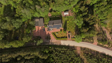 Hyperlapse-drone-shot-of-clouds-moving-over-a-solar-house-with-people-on-the-yard