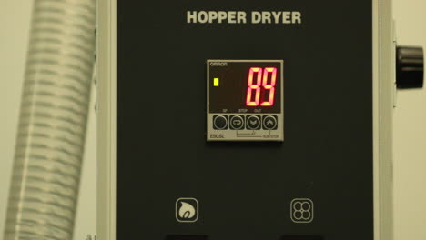 primer plano de la caja eléctrica de un secador de tolva con indicador de temperatura