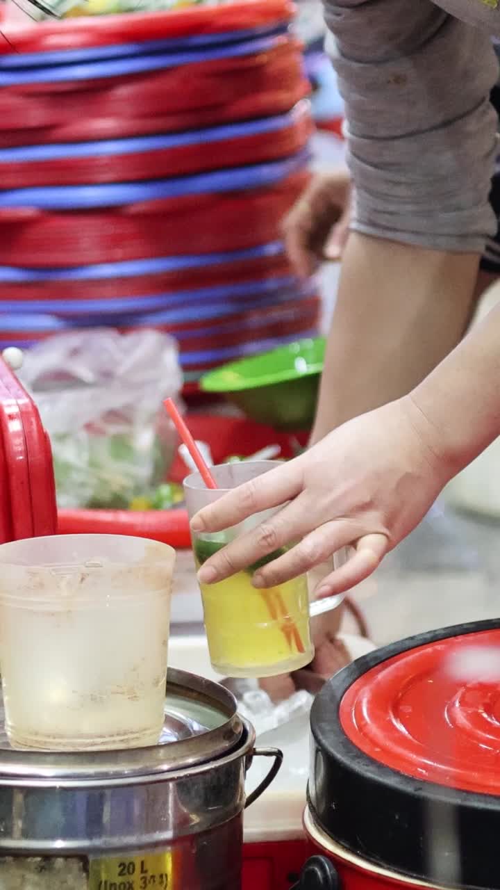 벤더는 비는 시장에서 술을 능숙하게 준비합니다.