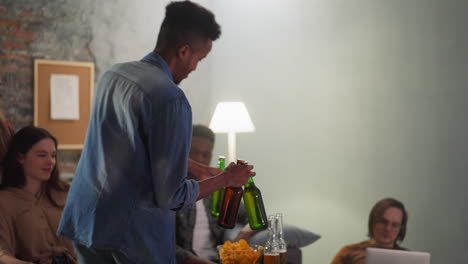 hombre negro lleva cerveza fría a los amigos en el juego de deportes