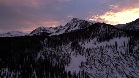 sunset drone view of colorful clouds and steep mountain peak