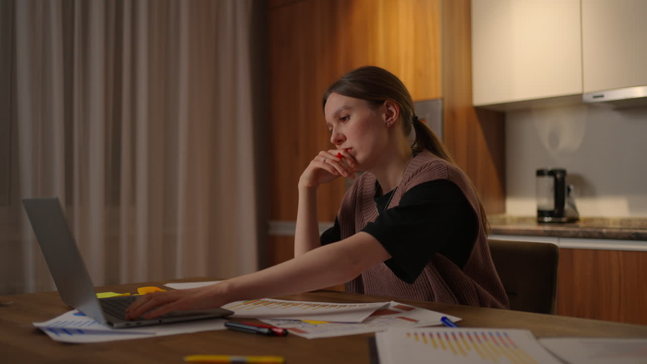 una vista lateral de una mujer estudiando remotamente desde casa viendo una conferencia aburrida después de un día duro. estudiante cansada en casa