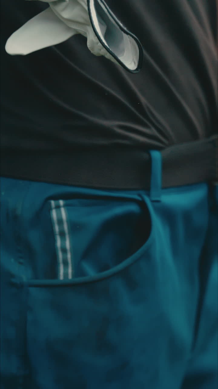 Male golfer hands close up pulling glove out of pocket in the rain in slow motion