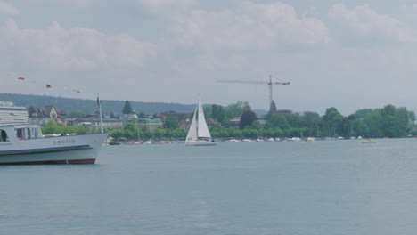 Tracking-shot-of-a-sailboat-on-Lake-Zurich-Switzerland-towards-the-pier