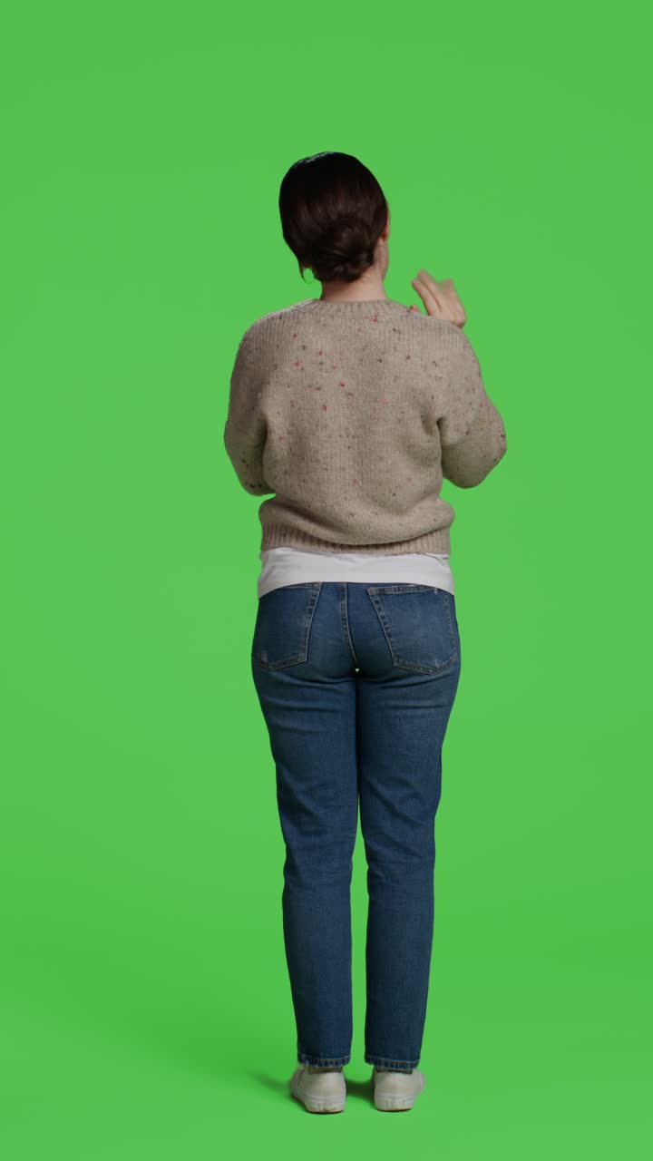 Vertical video: Back view of person greeting someone with wave