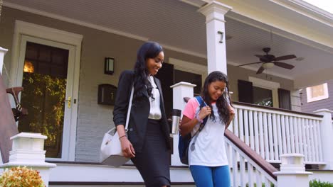 businesswoman mother walking daughter to school on way to work