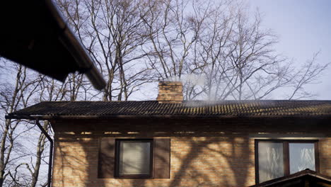 brick country house with chimney expelling smoke