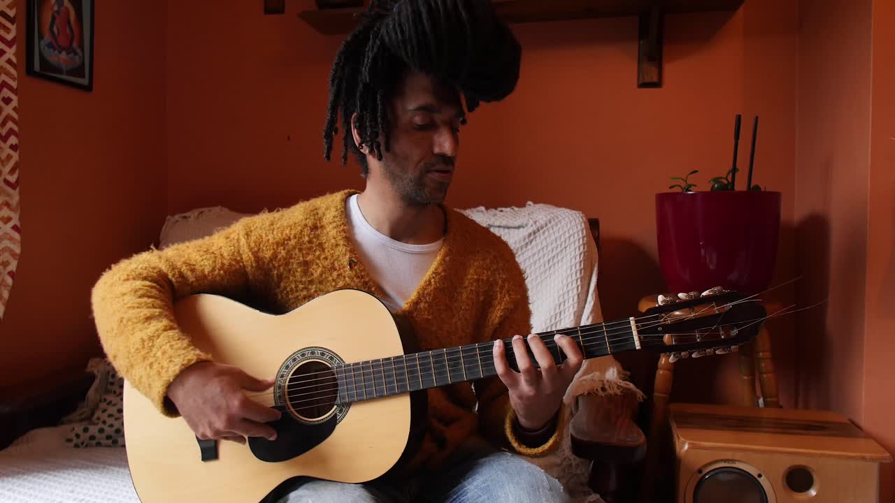 En charmerende mand, der øver en guitarsolo derhjemme