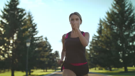 Sport-woman-running-on-park-road-at-summer.-Female-runner-training-outdoor