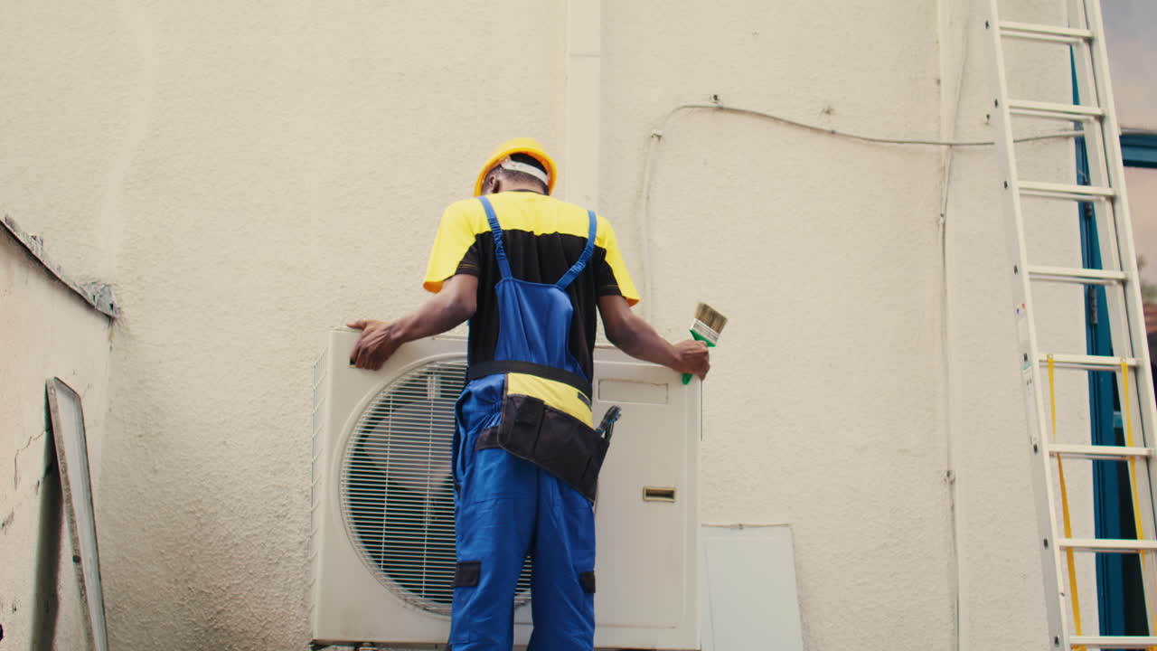 Worker sweeps debris in air conditioner