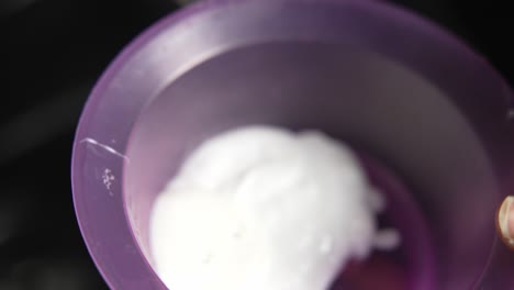 peluquero dejando caer el producto a base de aceite en un recipiente