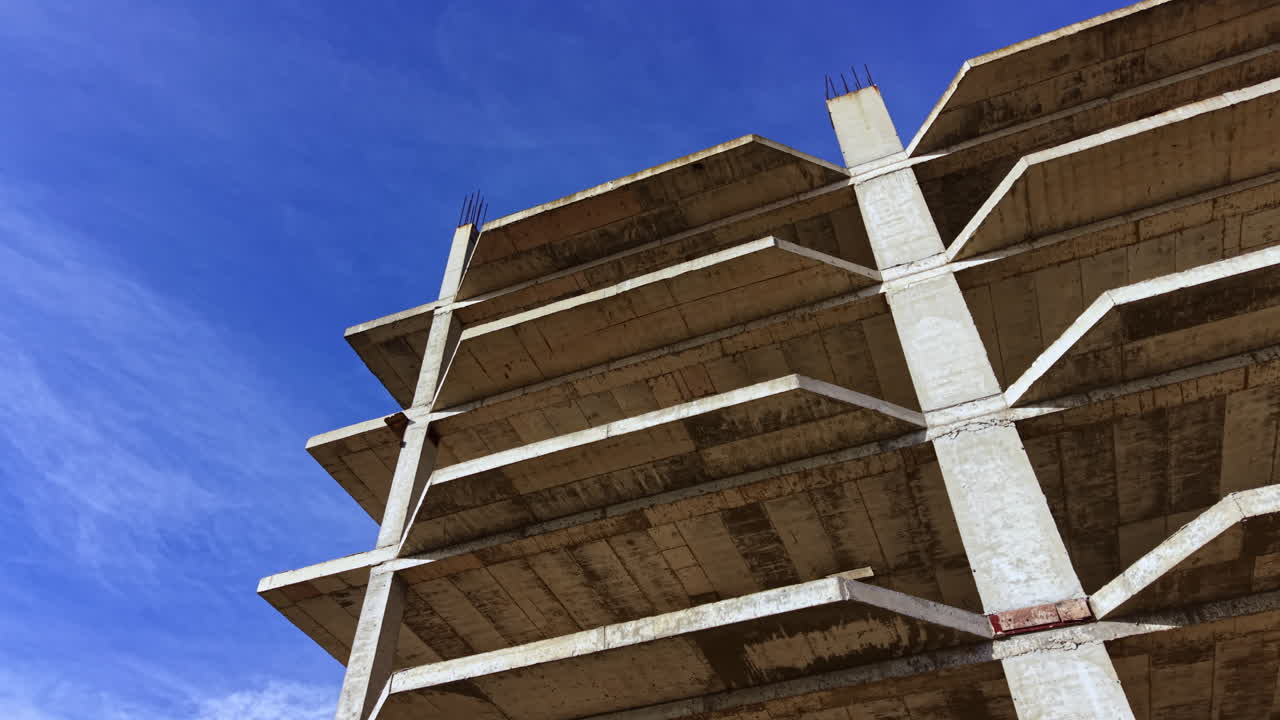Construction progress showcased in a skeletal building under a bright blue sky on a sunny day in an urban setting