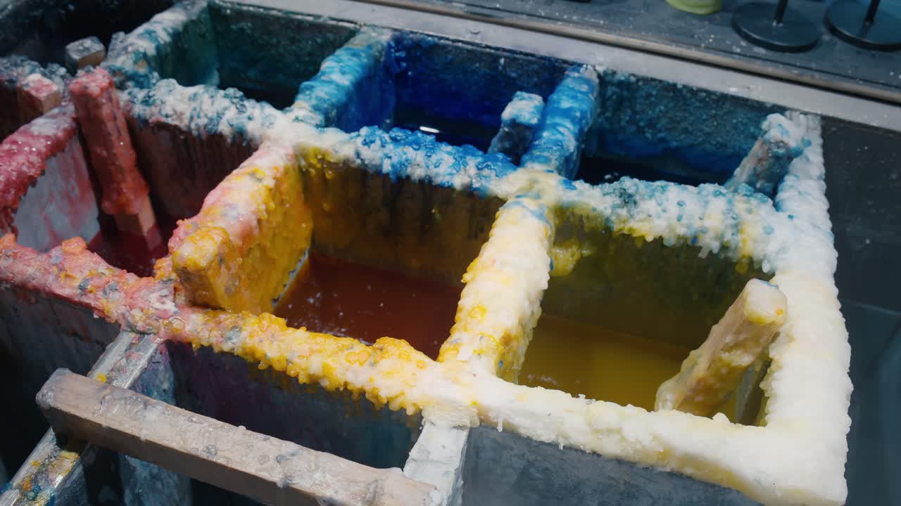 Cubas de inmersión de cera para la fabricación de velas en tonos vibrantes, tienda La Candela, Venecia.