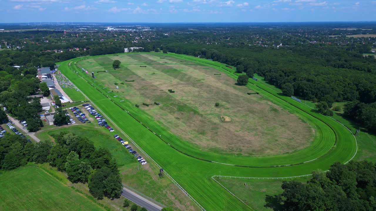 Horse gallop racecourse near a forest in Germany, parking lot visible. Perfect aerial view flight speed ramp hyper motion time lapse