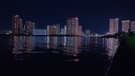 Night-light-Tokyo,-Tsukuda,-Toyosu-skyscrapers-and-bridge-the-Sumida-River-Yakatabune,-pleasure-boat