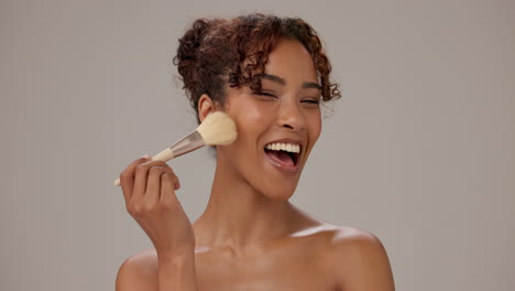 mujer aplicando maquillaje con un pincel