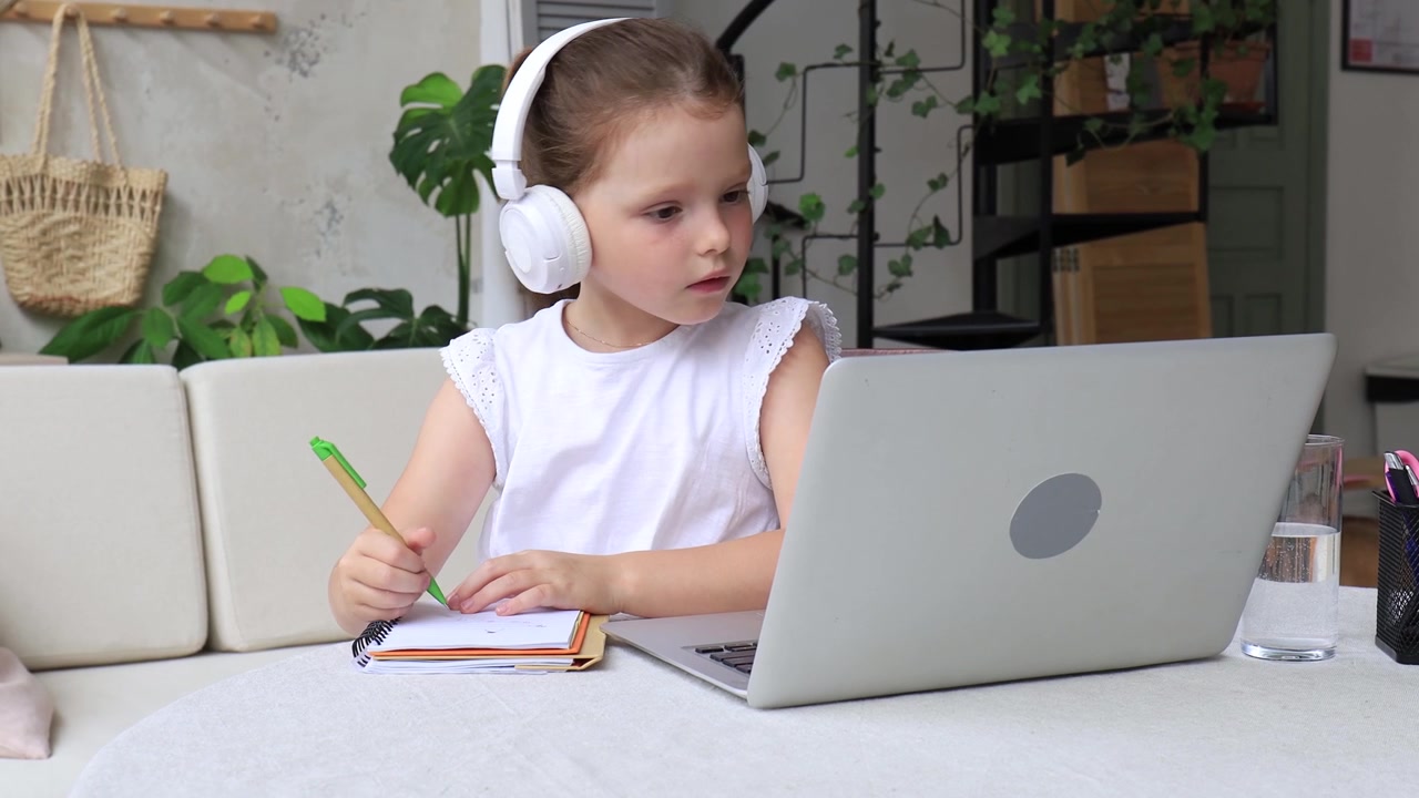 Focused Young Girl Learning Online at Home with Laptop