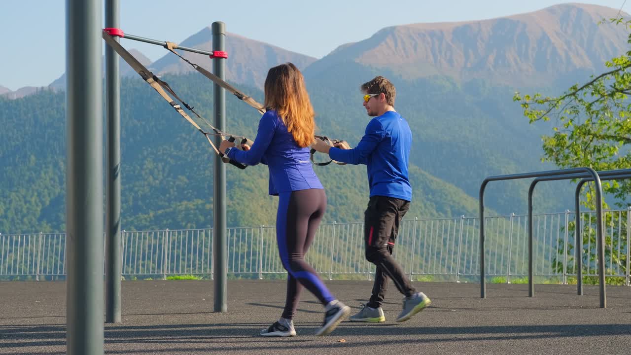 Couple training together using trx straps