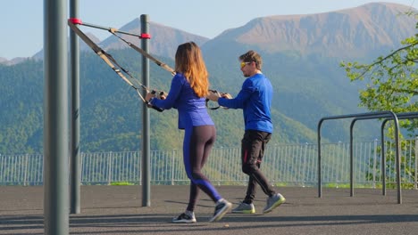 couple training together using trx straps