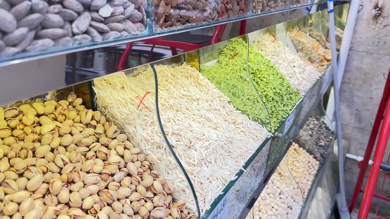 स्थानीय बाज़ार की दुकान में कटे हुए मेवे: पिस्ता, बादाम, हेज़लनट। ईरान के पुराने बाज़ार में उपलब्ध विभिन्न प्रकार के कच्चे और नमकीन मेवों का मिश्रण, जिसमें सूरजमुखी के बीज और अखरोट शामिल हैं। शाकाहारी, ऊर्जावान और पारंपरिक स्वस्थ भोजन।