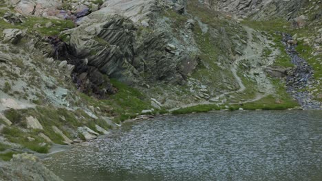 río pacífico junto a la montaña rocosa caminata en campagneda, valmalenco, lombardía, italia