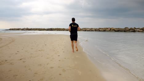 hombre corriendo en la playa, cámara lenta