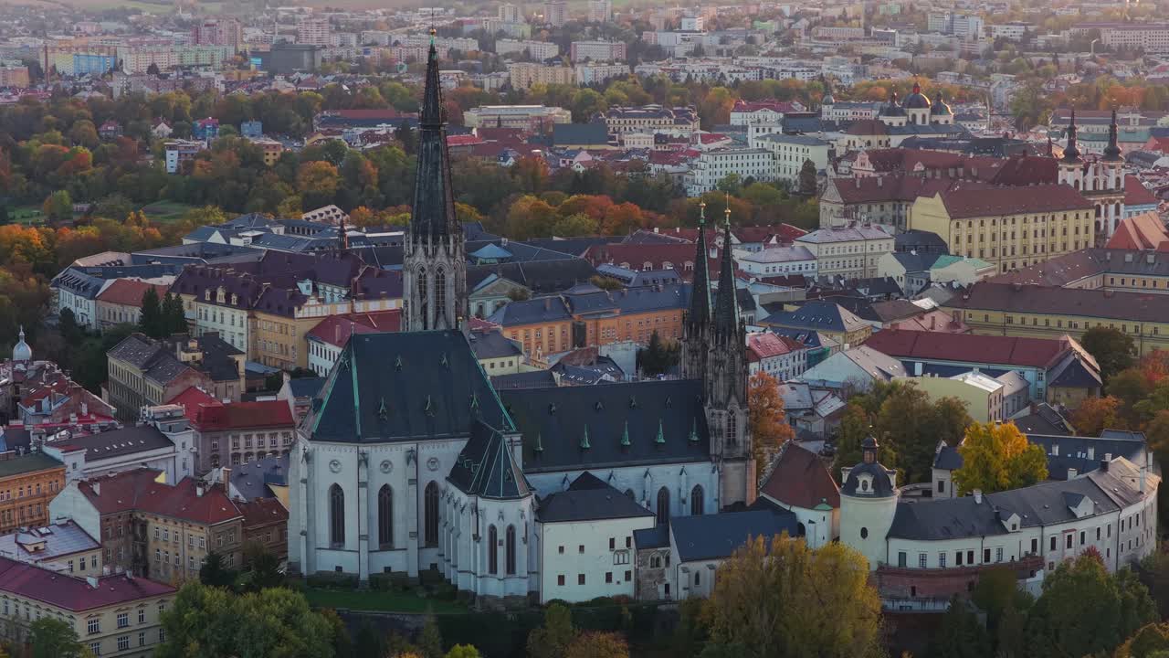 Cathedral of Saint Wenceslas in Olomouc captured from a drone during sunset with the city glowing in warm light and the skyline filled with historic charm and peaceful atmosphere
