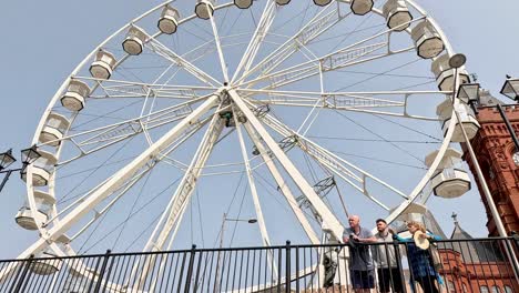 ferris wheel near clock tower in cardiff bay