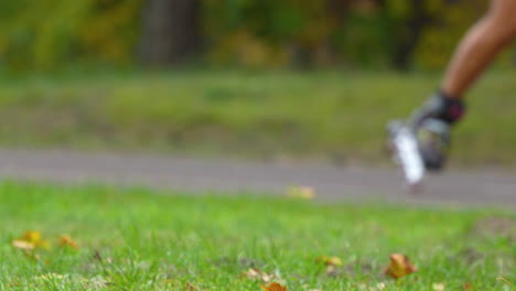 Male-skater-gracefully-moves-in-slow-motion,-gliding-near-lush-green-lawn