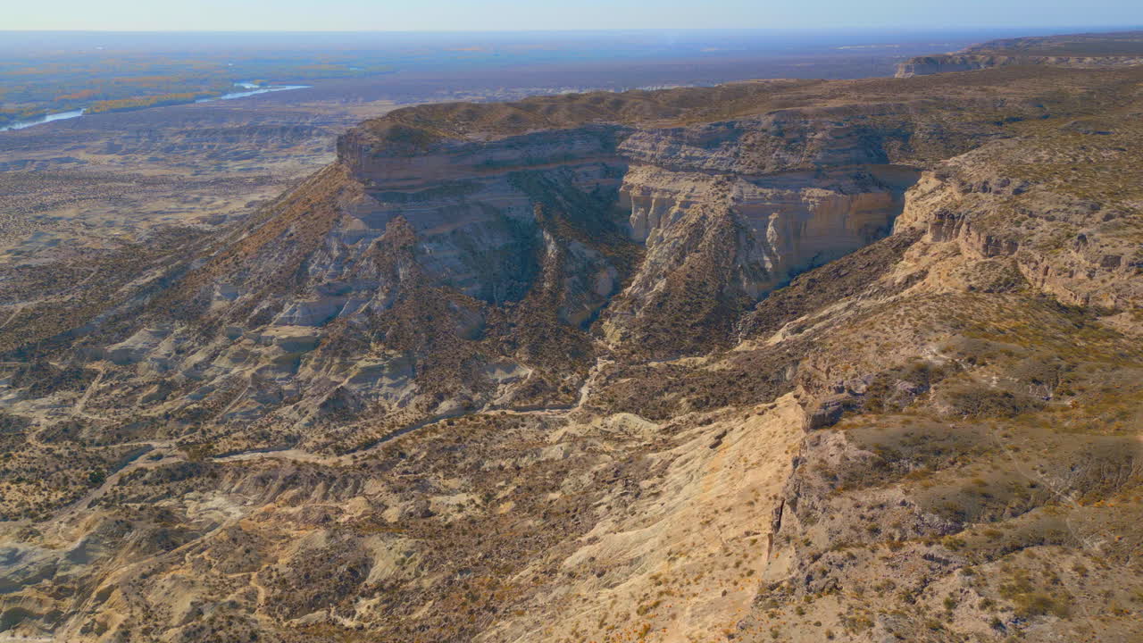 Aerial View of Vast Desert Canyon with Cliffs and Distant River