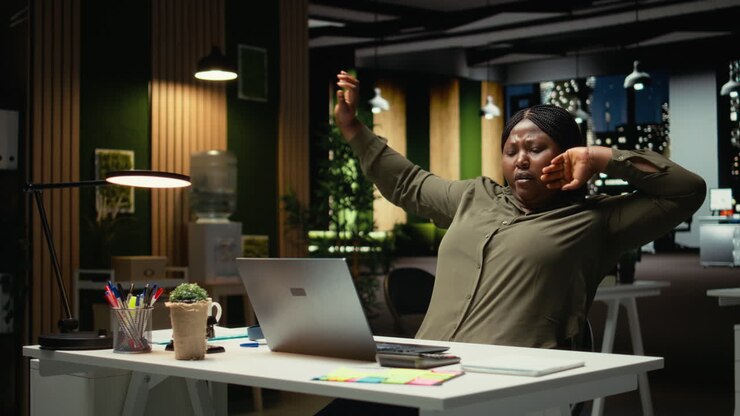Female office worker managing daily tasks at night with focus music on headset