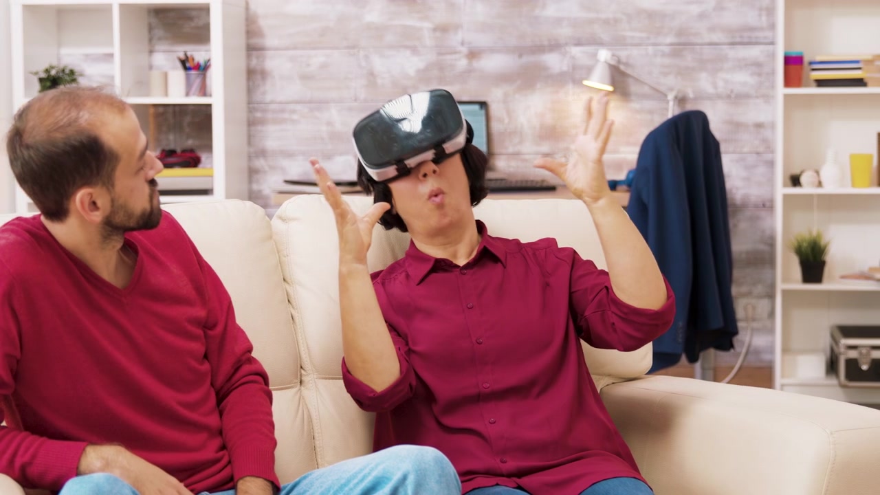 Joven ayudando a su madre a experimentar la realidad virtual en casa.