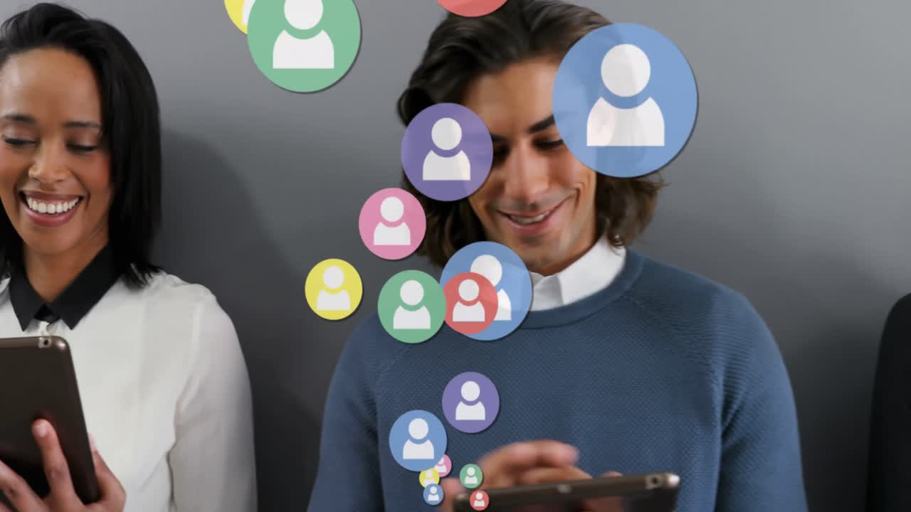 múltiples iconos de perfil flotando contra colegas de oficina que usan dispositivos electrónicos