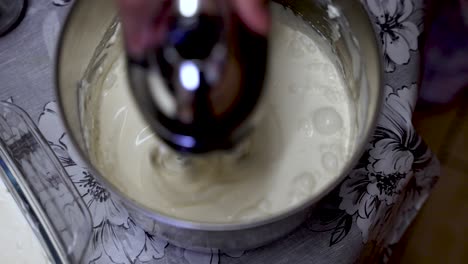 birds eye view of cream being machined whisked in metal container