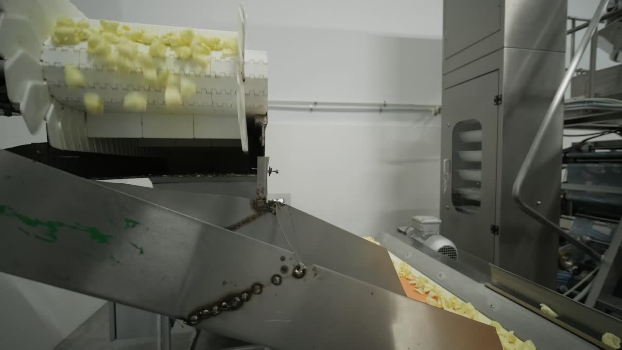 la línea de producción de la fábrica mueve las patatas fritas doradas después de freír. línea de fabricación de la fábrica de pasta
