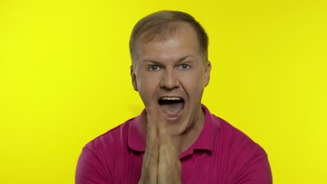 portrait of young caucasian man posing in pink t-shirt. satisfied handsome guy celebrates, wins