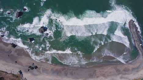 crashing waves near the coquille river mouth meeting the pacific ocean in bandon oregon