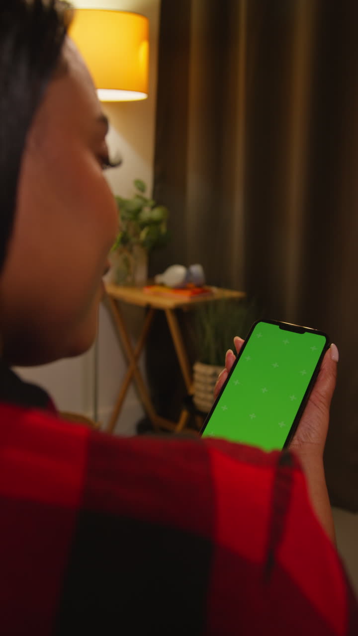 mujer sosteniendo un teléfono con una pantalla verde