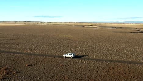 parallax motion follow offroad vehicle driving on desert road in iceland, arid landscape