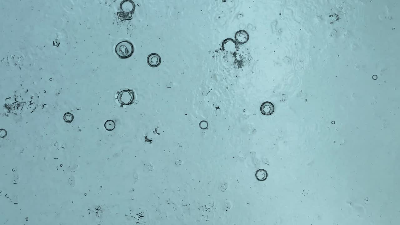 fondo vertical abstracto de gotas de lluvia, vista desde debajo del techo espejado contra la dirección de la gota de lluvia desde el cielo, poca luz natural mientras llueve