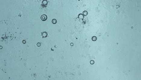 abstract vertical background from raindrops, view from under the mirrored ceiling against the rain drop direction from sky, low light natural while raining