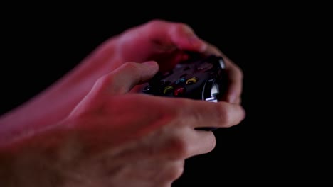 playing video games in a darkened room with a black background close up on a controller buttons playing quickly