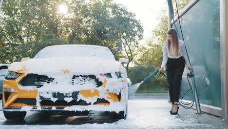 mujer lavando un coche amarillo en un lavado de coches