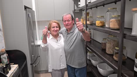 los clientes felices dan un pulgar hacia arriba a la cámara en su área de despensa recién diseñada en su nueva casa