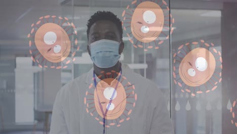 Multiple-covid-19-cells-moving-against-portrait-of-african-american-male-doctor-wearing-face-mask