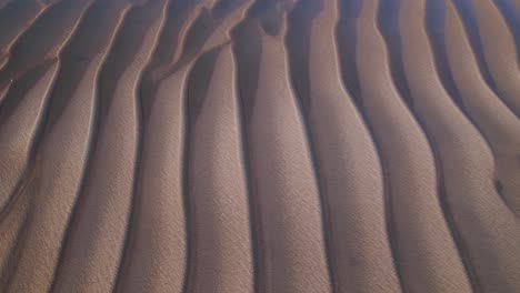 wave pattern of sandy desert with water overflowing it, aerial drone shot