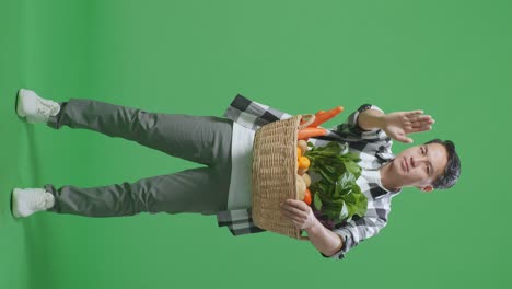 hombre sosteniendo una canasta de verduras