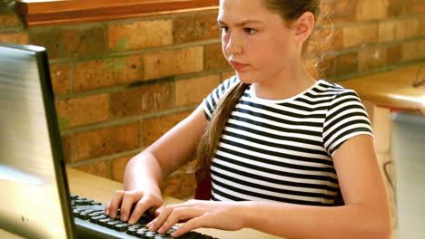 alumno lindo mirando la computadora portátil en el aula